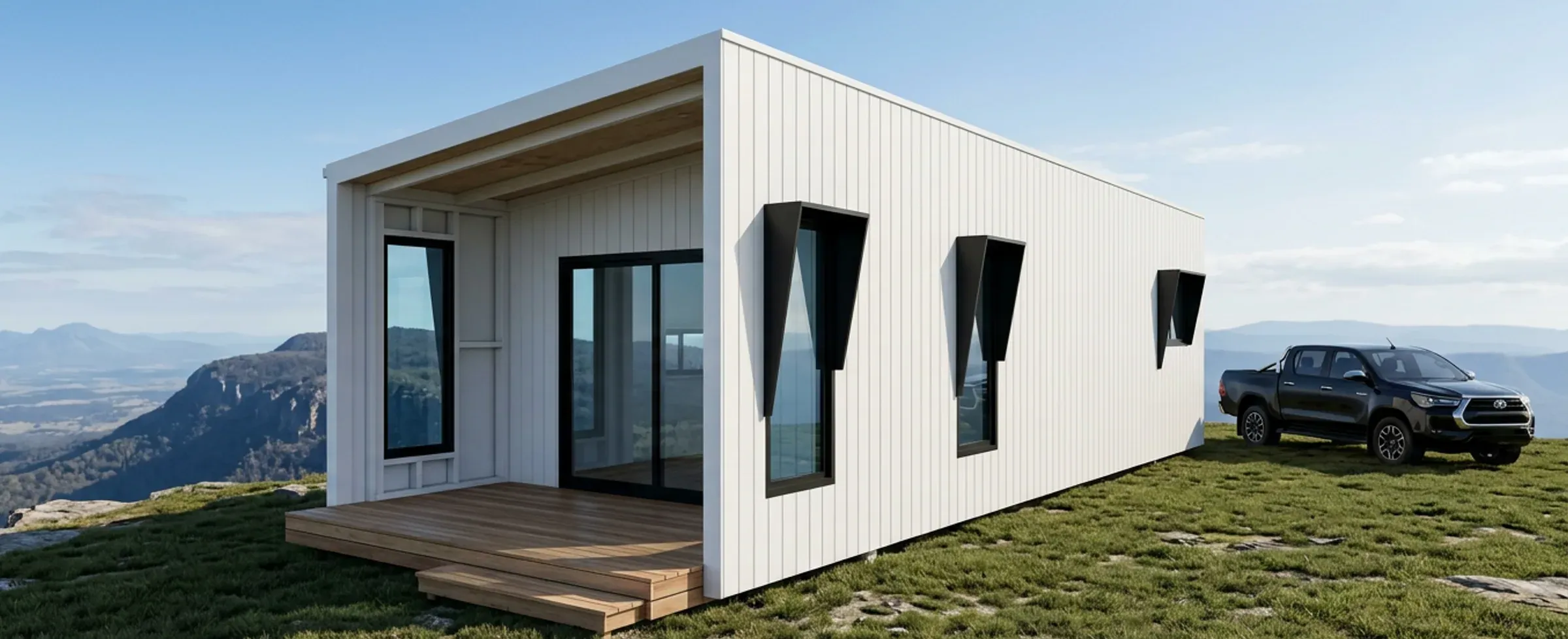 Render of the 1 bedroom Retreat in white cladding with a timber entry deck and a ute parked beside it, on a hilltop with distant ranges.