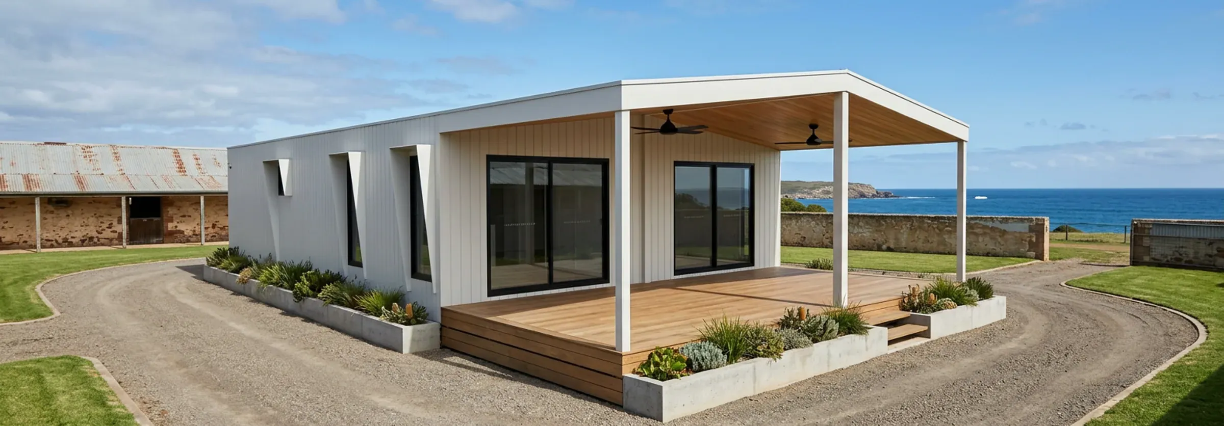 Render of the 3 bedroom Plan E in white cladding with a timber-lined covered deck, ceiling fans and a gravel driveway by the sea.